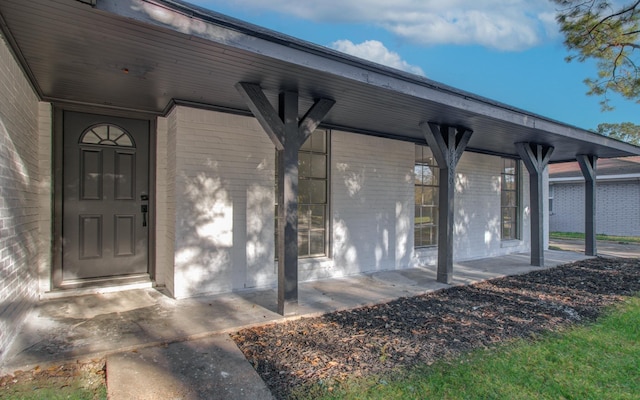 doorway to property with brick siding