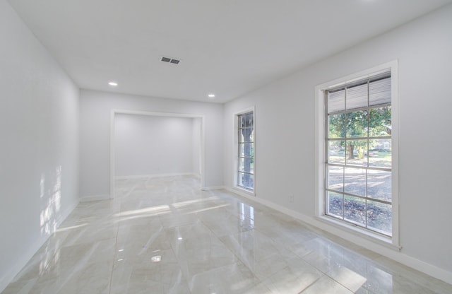 spare room with recessed lighting and baseboards