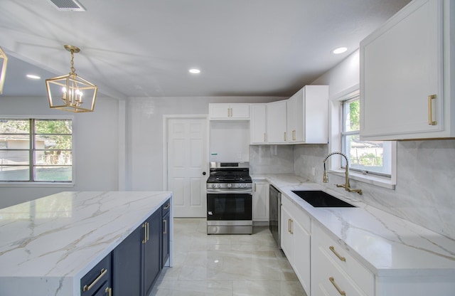 kitchen featuring stainless steel appliances, a sink, tasteful backsplash, blue cabinets, and white cabinetry