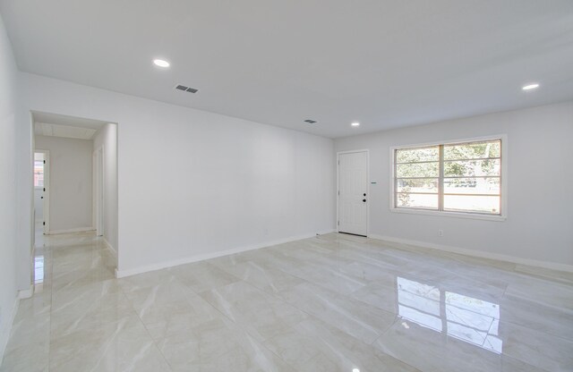 empty room with recessed lighting, baseboards, and light marble finish floors