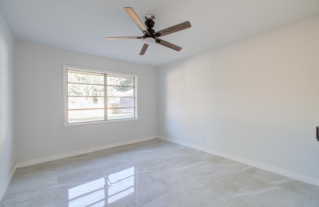 unfurnished room with a ceiling fan and baseboards