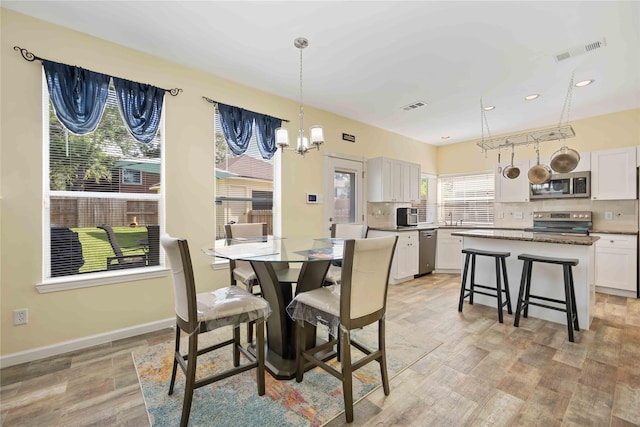17906 Camden Oaks Ln, Richmond, TX 77407 - dining space featuring a chandelier, light wood-style flooring, recessed lighting, and baseboards