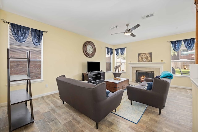 17906 Camden Oaks Ln, Richmond, TX 77407 - living area featuring wood finished floors, ceiling fan, a tiled fireplace, and baseboards