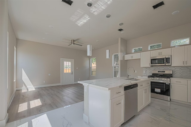 7207 Force St, Houston, TX 77020 - kitchen featuring appliances with stainless steel finishes, a sink, tasteful backsplash, hanging light fixtures, and white cabinets