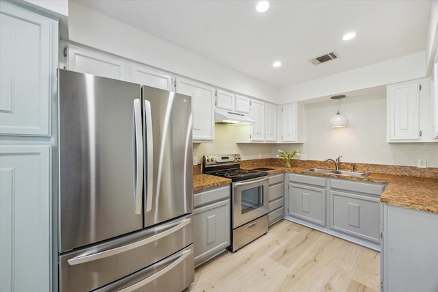 2515 Bering Dr Unit 11, Houston, TX 77057 - kitchen featuring stainless steel appliances, under cabinet range hood, light wood-type flooring, recessed lighting, and white cabinetry