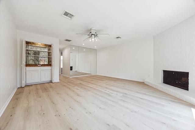 2515 Bering Dr Unit 11, Houston, TX 77057 - unfurnished living room featuring ceiling fan, light wood-style flooring, and a fireplace