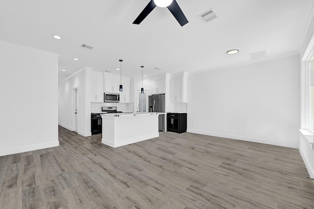 116 York St, South Houston, TX 77587 - kitchen with appliances with stainless steel finishes, open floor plan, crown molding, a ceiling fan, and a kitchen island with sink