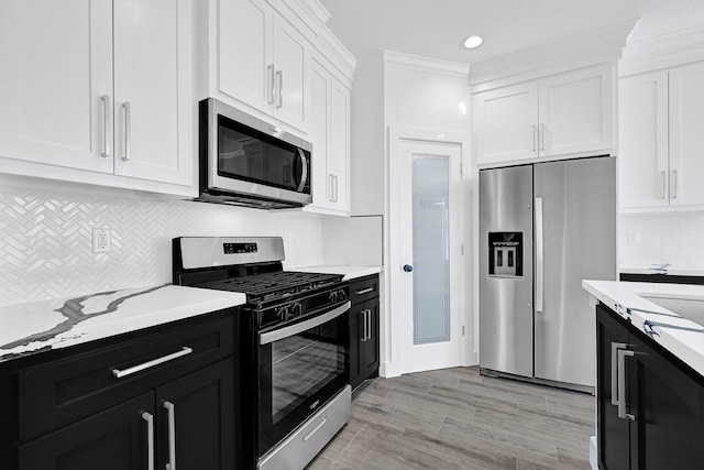 116 York St, South Houston, TX 77587 - kitchen with appliances with stainless steel finishes, dark cabinets, white cabinetry, tasteful backsplash, and light stone counters