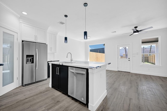 116 York St, South Houston, TX 77587 - kitchen featuring appliances with stainless steel finishes, a sink, a center island with sink, light wood-style floors, and light countertops