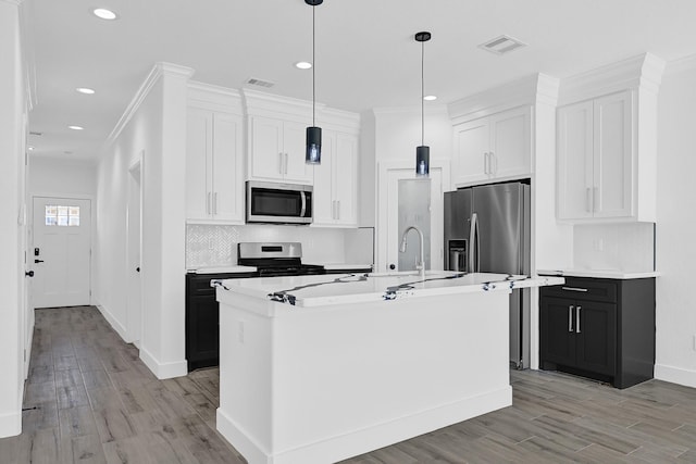 116 York St, South Houston, TX 77587 - kitchen with appliances with stainless steel finishes, light wood-style flooring, backsplash, recessed lighting, and a center island with sink