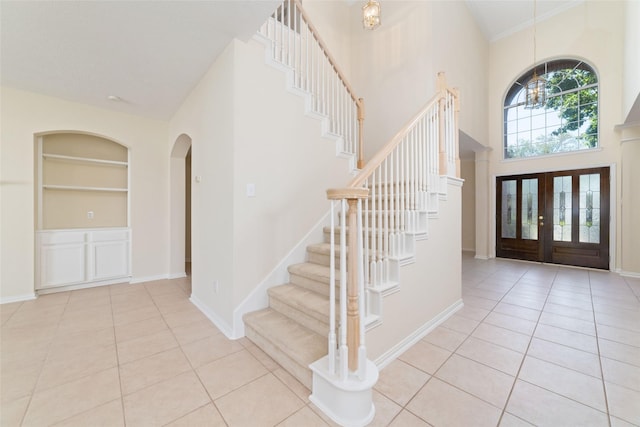 12236 S Shadow Cove Dr, Houston, TX 77082 - tiled foyer featuring stairway, a towering ceiling, arched walkways, and baseboards
