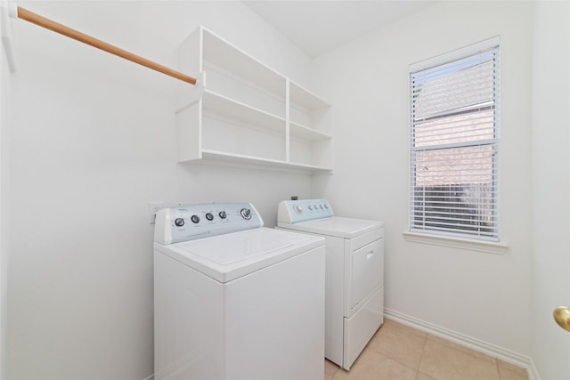12236 S Shadow Cove Dr, Houston, TX 77082 - laundry area with washer and dryer, baseboards, and light tile patterned floors