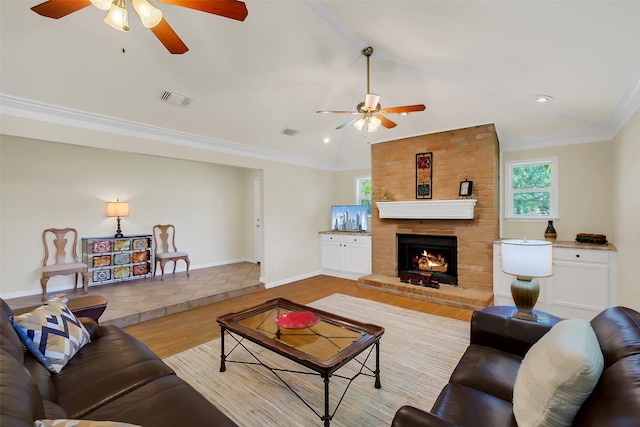 2810 Cottonwood Dr, Katy, TX 77493 - living room with ceiling fan, light wood finished floors, baseboards, a brick fireplace, and crown molding