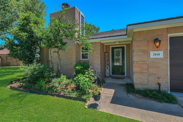2810 Cottonwood Dr, Katy, TX 77493 - entrance to property with brick siding, a lawn, and a chimney