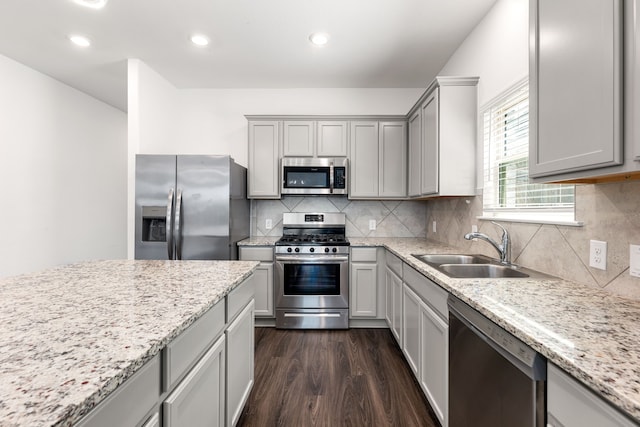 6223 Milbridge Creek Ln, Katy, TX 77493 - kitchen with appliances with stainless steel finishes, a sink, gray cabinetry, dark wood-style flooring, and light stone countertops