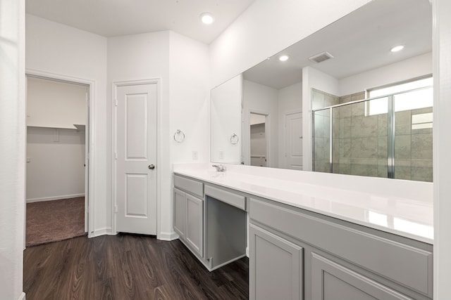 6223 Milbridge Creek Ln, Katy, TX 77493 - bathroom with a stall shower, a walk in closet, wood finished floors, vanity, and baseboards