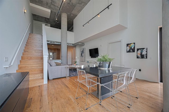 5005 Hidalgo St Unit 410, Houston, TX 77056 - dining space with a high ceiling, light wood-style flooring, and stairs