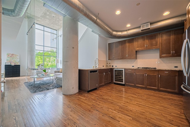 5005 Hidalgo St Unit 410, Houston, TX 77056 - kitchen with wine cooler, appliances with stainless steel finishes, wood finished floors, tasteful backsplash, and a sink