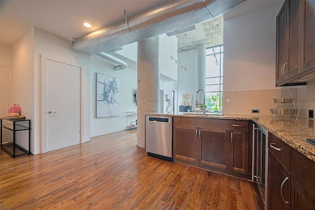 5005 Hidalgo St Unit 410, Houston, TX 77056 - kitchen with stainless steel dishwasher, a sink, light wood-style floors, and light stone countertops