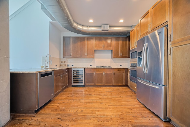 5005 Hidalgo St Unit 410, Houston, TX 77056 - kitchen with stainless steel appliances, beverage cooler, light wood finished floors, light stone countertops, and a sink