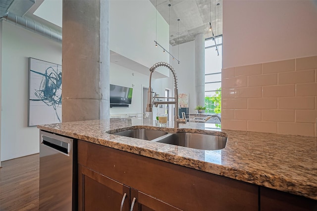 5005 Hidalgo St Unit 410, Houston, TX 77056 - kitchen featuring a sink, stainless steel dishwasher, wood finished floors, light stone countertops, and a towering ceiling