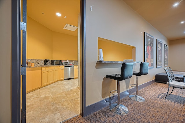 5005 Hidalgo St Unit 410, Houston, TX 77056 - kitchen with dishwasher, light brown cabinetry, black microwave, recessed lighting, and a kitchen breakfast bar