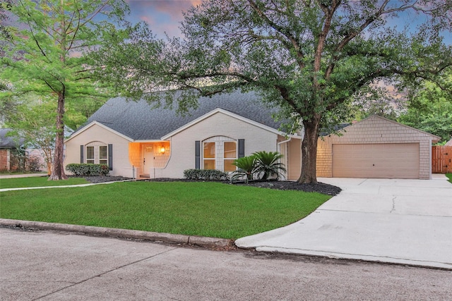 ranch-style house featuring driveway, a lawn, and brick siding