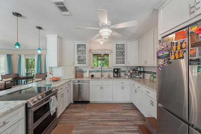 4701 County Road 747a, Brazoria, TX 77422 - kitchen with appliances with stainless steel finishes, a sink, white cabinetry, glass insert cabinets, and a textured ceiling
