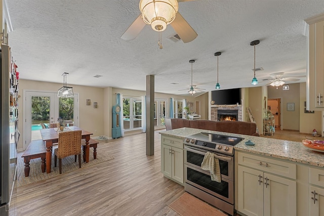 4701 County Road 747a, Brazoria, TX 77422 - kitchen with double oven range, ceiling fan, open floor plan, a fireplace, and hanging light fixtures