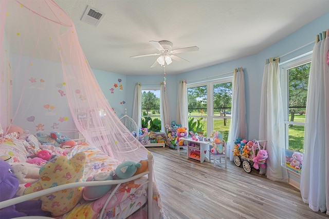 4701 County Road 747a, Brazoria, TX 77422 - bedroom featuring multiple windows, wood finished floors, and ceiling fan