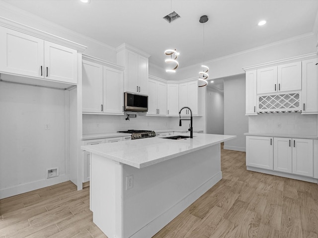 538 Rd 660, Dayton, TX 77535 - kitchen featuring appliances with stainless steel finishes, a sink, tasteful backsplash, white cabinets, and light wood-style floors