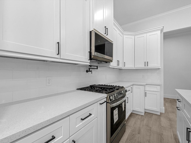 538 Rd 660, Dayton, TX 77535 - kitchen with stainless steel appliances, ornamental molding, white cabinets, backsplash, and light wood-style floors