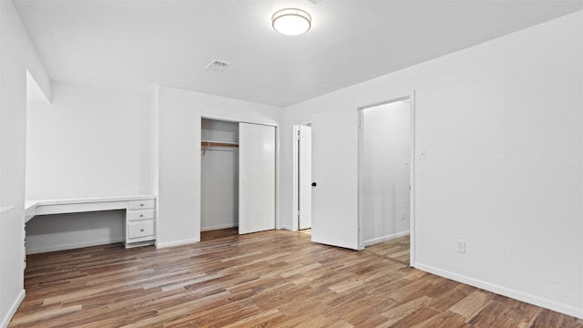 2139 E Settlers Way, The Woodlands, TX 77380 - unfurnished bedroom with light wood-style flooring, a closet, and baseboards