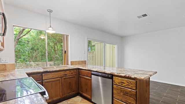 2139 E Settlers Way, The Woodlands, TX 77380 - kitchen with stainless steel dishwasher, a sink, brown cabinetry, electric stove, and hanging light fixtures
