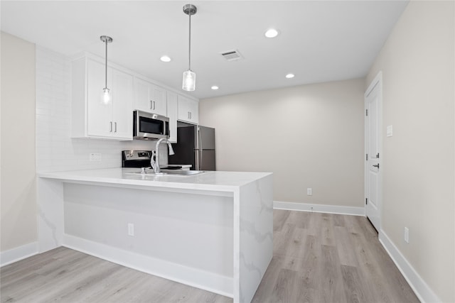 1118 W Cottage St, Houston, TX 77009 - kitchen with stainless steel appliances, white cabinetry, a peninsula, light countertops, and recessed lighting