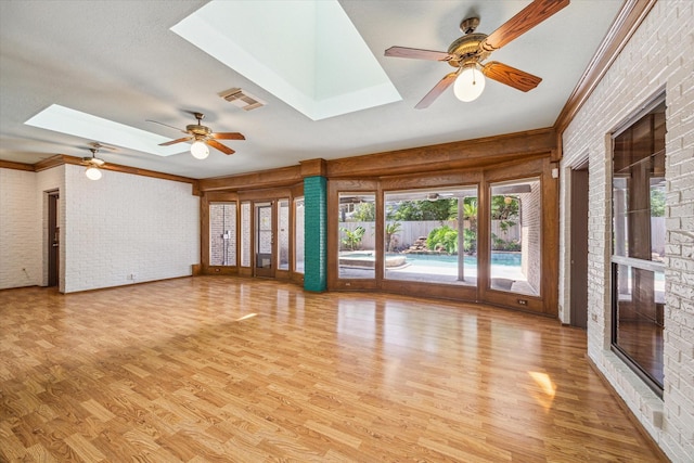 15706 Pinewood Cove Dr, Houston, TX 77062 - spare room with a skylight, a ceiling fan, light wood-style flooring, brick wall, and ornamental molding