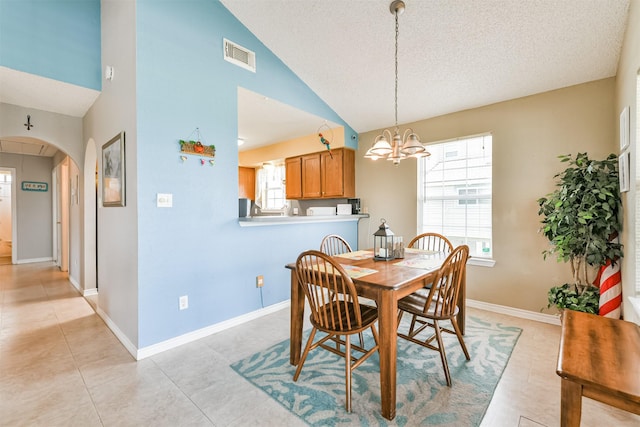4030 Fort Bend Dr, Galveston, TX 77554 - dining room with a chandelier, arched walkways, plenty of natural light, lofted ceiling, and baseboards