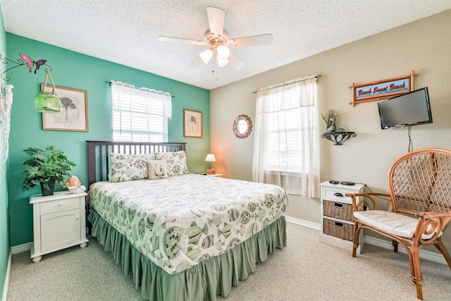 4030 Fort Bend Dr, Galveston, TX 77554 - bedroom featuring multiple windows, light carpet, a textured ceiling, baseboards, and a ceiling fan