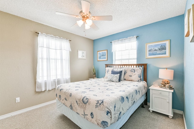 4030 Fort Bend Dr, Galveston, TX 77554 - bedroom with light carpet, baseboards, a textured ceiling, and ceiling fan