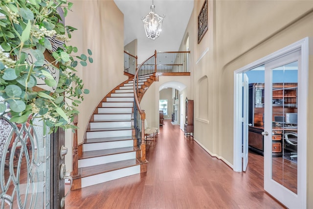 24628 Hosford Meadows Dr, Porter, TX 77365 - entrance foyer with a high ceiling, wood finished floors, a chandelier, arched walkways, and stairway