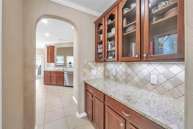 24628 Hosford Meadows Dr, Porter, TX 77365 - kitchen featuring dishwasher, arched walkways, ornamental molding, light tile patterned floors, and tasteful backsplash