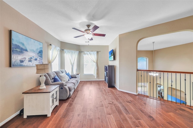 24628 Hosford Meadows Dr, Porter, TX 77365 - living area featuring a ceiling fan, baseboards, wood finished floors, and arched walkways