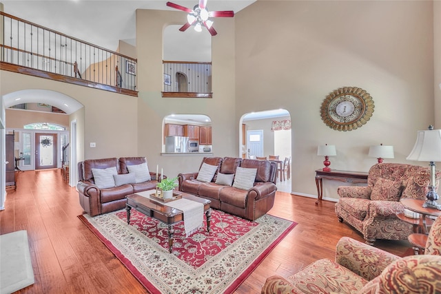 24628 Hosford Meadows Dr, Porter, TX 77365 - living area featuring arched walkways, ceiling fan, a towering ceiling, healthy amount of natural light, and wood finished floors