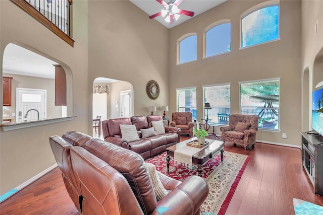 24628 Hosford Meadows Dr, Porter, TX 77365 - living area featuring arched walkways, a towering ceiling, ceiling fan, baseboards, and dark wood finished floors
