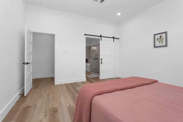 4021 King St, Houston, TX 77026 - bedroom with a barn door, wood finished floors, baseboards, and recessed lighting