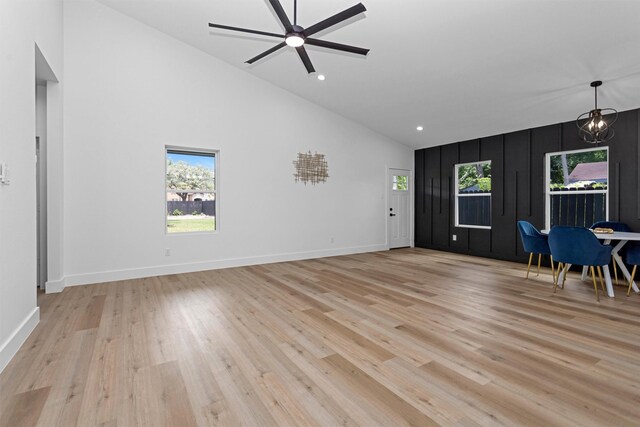 4021 King St, Houston, TX 77026 - unfurnished living room with high vaulted ceiling, a ceiling fan, light wood-type flooring, a chandelier, and baseboards