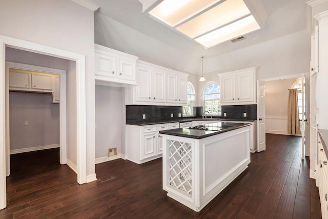 14003 Timbergreen Dr, Magnolia, TX 77355 - kitchen with dark countertops, white cabinets, dark wood-type flooring, and decorative backsplash
