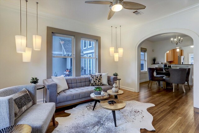924 E 27th St, Houston, TX 77009 - living area with arched walkways, wood finished floors, ornamental molding, a ceiling fan, and baseboards