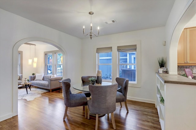 924 E 27th St, Houston, TX 77009 - dining room featuring arched walkways, wood finished floors, a chandelier, and baseboards
