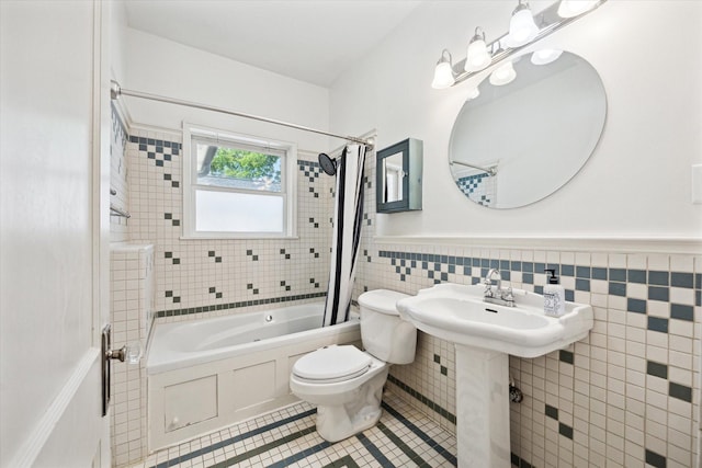 924 E 27th St, Houston, TX 77009 - bathroom with shower / tub combo with curtain, toilet, tile patterned floors, tile walls, and a wainscoted wall